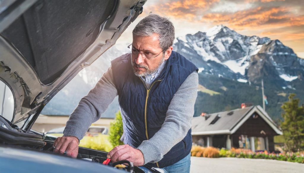 homme 60 ans vérifie niveau huile moteur de sa voiture suzuki - entretien et réparation voiture en suisse