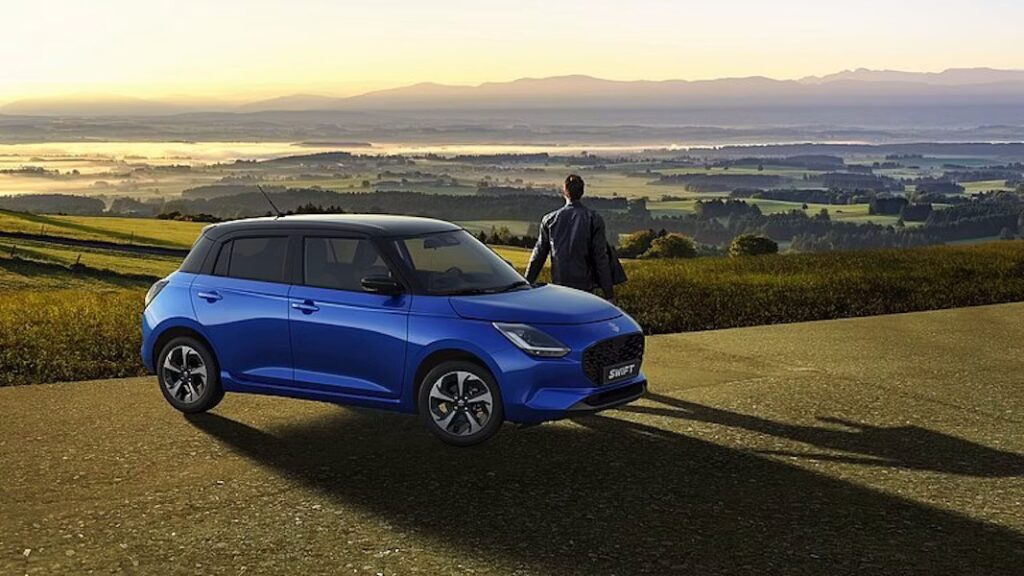 homme avec suzuki swift bleu lors de vacances en voiture regardant à l'horizon