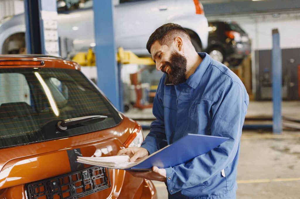 controle expertise voiture en suisse homme vérifie suzuki swift dans garage automobile à aigle