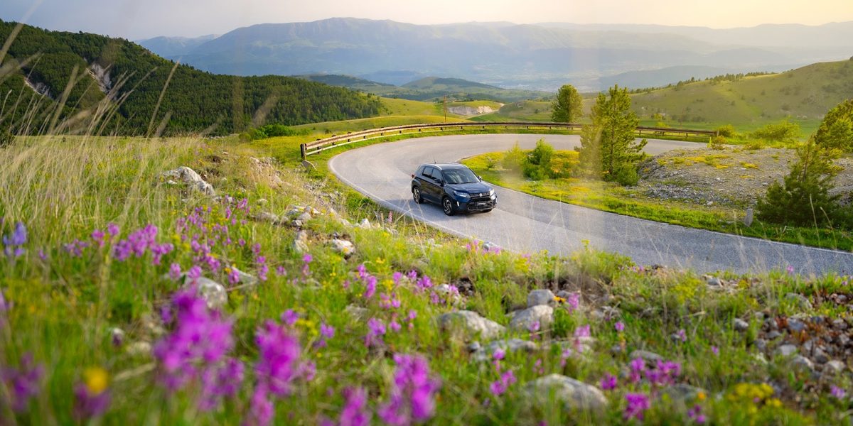 suzuki vitara hybrid 4x4 2024 sur route de montagne vers aigle en suisse dans les alpes suisses partir en vacances en voiture